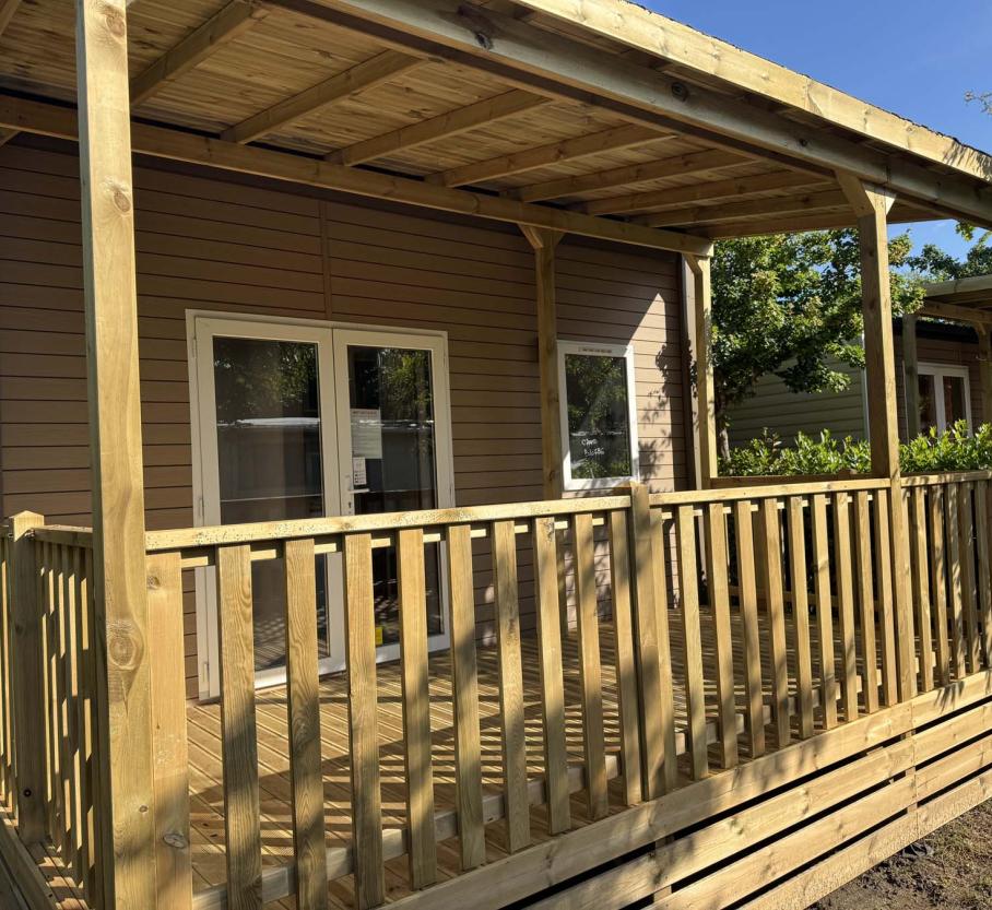 Bright wooden porch, cozy and serene, surrounded by greenery.
