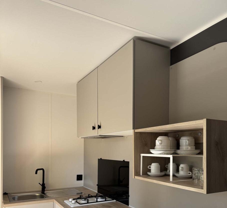 Modern, minimalist kitchen with light wood and organized dishes, cozy atmosphere.