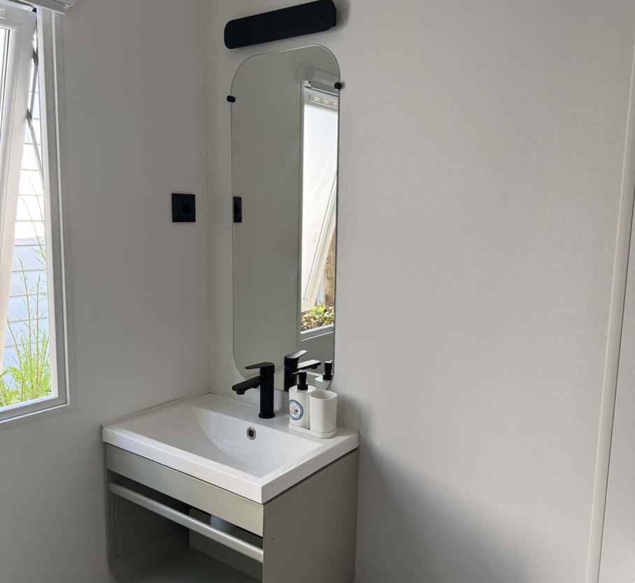 Bright, modern bathroom with elegant mirror and minimalist sink.