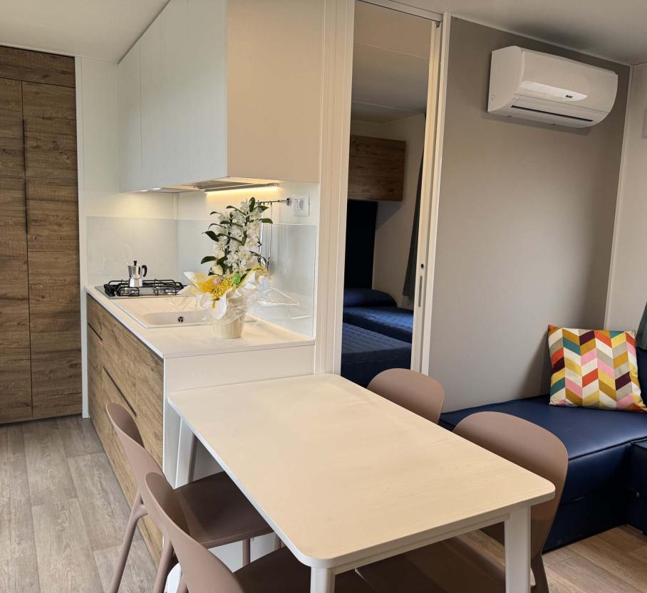 Bright modern apartment with compact kitchen and cozy colorful living area.